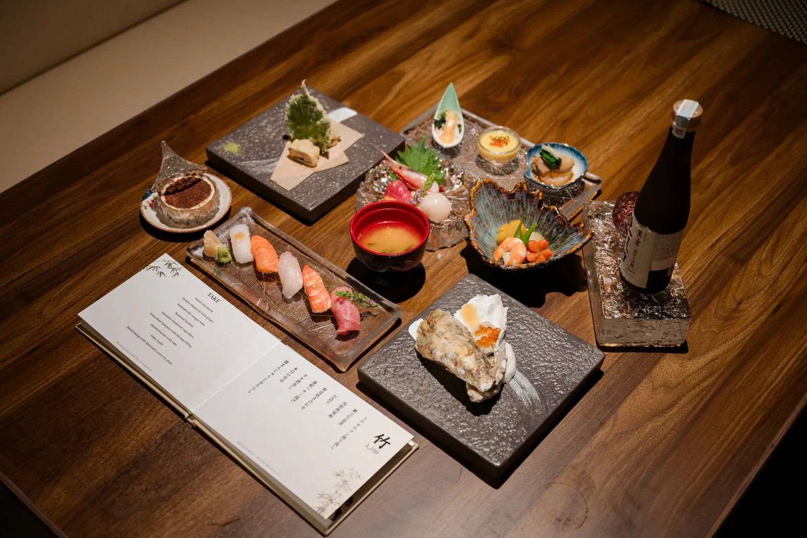 An omakase spread on the table with the course menu