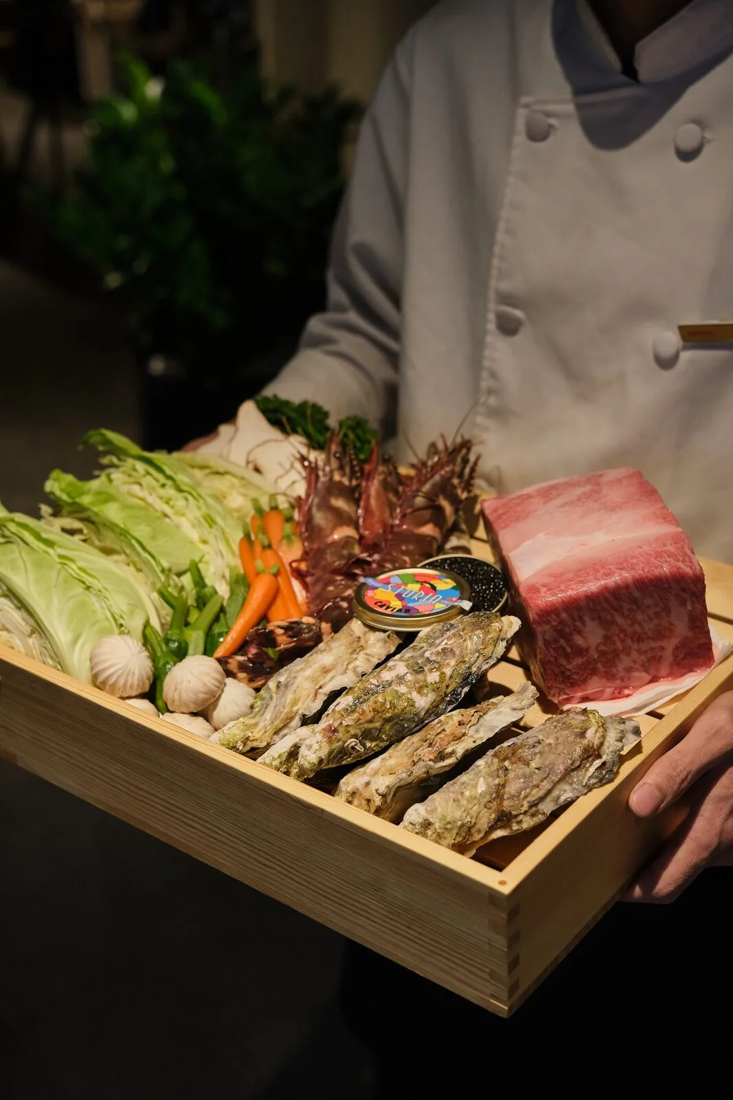 A tray of fresh ingredients arranged beside the teppan