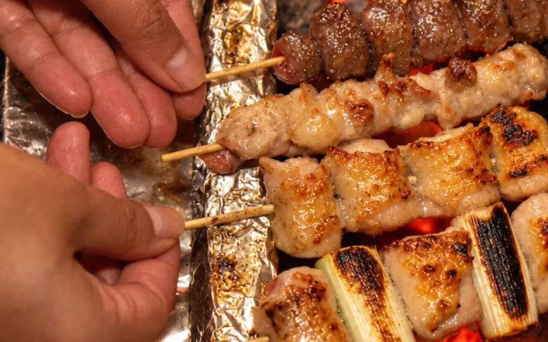 Xiên yakitori nướng trên bếp than binchotan đỏ rực